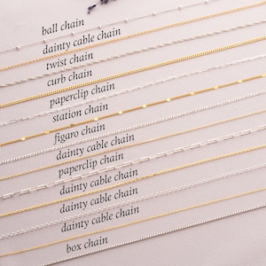 May include: A close-up of 13 different types of chain styles, including ball chain, dainty cable chain, twist chain, curb chain, paperclip chain, station chain, figaro chain, and box chain. The chains are arranged in rows, with the names of each chain style labeled below them.