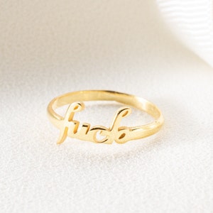 May include: A gold-colored ring with the word "fuck" written in cursive.