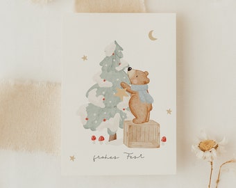 May include: A watercolor illustration of a brown bear decorating a Christmas tree with a gold star. The bear is standing on a wooden box. The background is a light blue with white clouds and stars. The text "frohes Fest" is written in cursive at the bottom of the image.