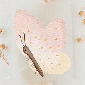 Könnte beinhalten: Aquarell-Illustration eines Schmetterlings mit rosa und gelben Flügeln, braunem Körper und Fühlern. Der Schmetterling hat kleine orangefarbene Punkte auf seinen Flügeln. Das Bild hat eine weiche, pastellfarbene Farbpalette mit weißem Hintergrund und dekorativen Elementen.