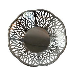 Op de afbeelding: Zilveren decoratieve kom met een delicaat, ingewikkeld ontwerp. De kom heeft een ronde vorm met een gegolfde rand en een open midden.