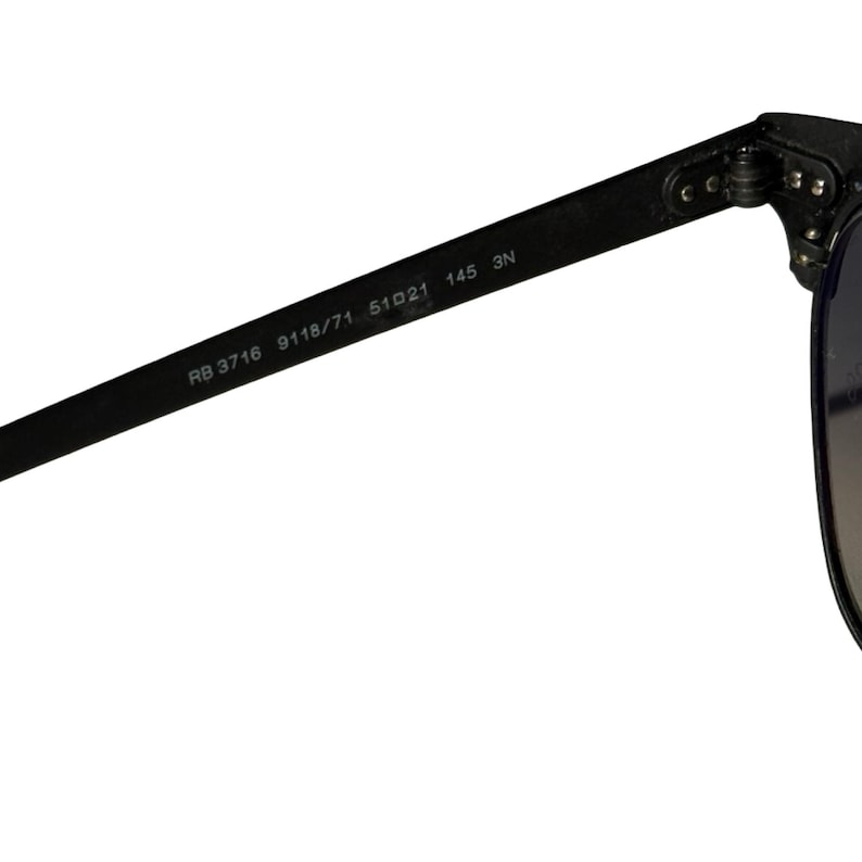 May include: Close-up of a black sunglasses arm with the text "RB 3716 9118/71 51o21 145 3N". The sunglasses arm is made of a matte black material and is attached to the frame with a hinge.