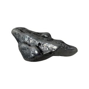 Op de afbeelding: Een ruwe, grijze, metalen steen met een onregelmatige vorm. De steen heeft een getextureerd oppervlak en lijkt van metaal te zijn.