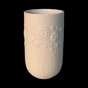 Op de afbeelding: Witte keramische mok met een zwart handvat en de tekst "But First, Coffee" in een zwarte, vette letter. De mok staat op een wit oppervlak. Geschikt voor warme dranken.