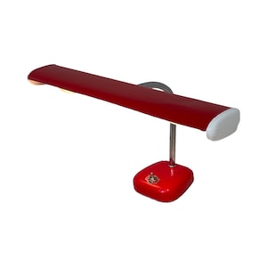 Op de afbeelding: Een rode vintage bureaulamp met een lange, rechthoekige kap en een verstelbare arm van chroom. De lamp heeft een witte schakelaar op de basis.