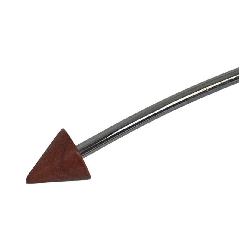 May include: A close-up of a brown wooden triangle-shaped tip attached to a silver metal rod.