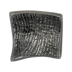 May include: A small, curved, silver-colored metal piece with a textured surface.