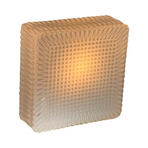 May include: A square, frosted glass light fixture with a textured, grid-like pattern on the front and sides. The fixture emits a warm, yellow glow, suggesting an internal light source. The edges have a decorative, ridged design.