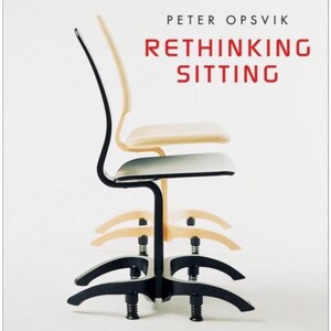 Puede incluir: Una pila de sillas ergon&oacute;micas con marcos negros y asientos de color claro. Las sillas est&aacute;n dispuestas verticalmente, mostrando su dise&ntilde;o. La portada del libro en el fondo dice "Rethinking Sitting" de Peter Opsvik.