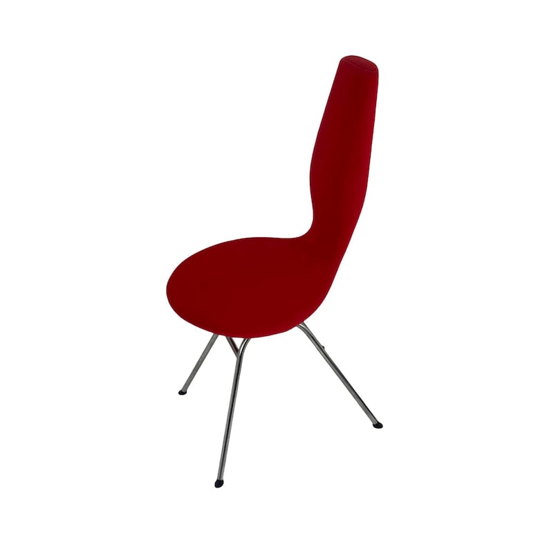 May include: A red upholstered chair with a unique, curved back and a chrome base with four legs.