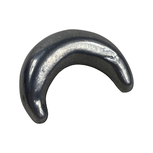 Op de afbeelding: Een zilverkleurige metalen haak in de vorm van een halve maan.