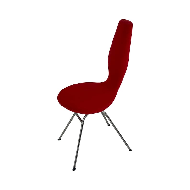 May include: A red upholstered chair with a unique, curved back and a chrome, four-legged base.
