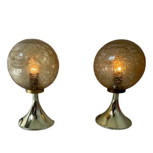 Puede incluir: Dos lámparas de mesa vintage con base dorada y pantalla de forma esférica marrón con un patrón texturizado.