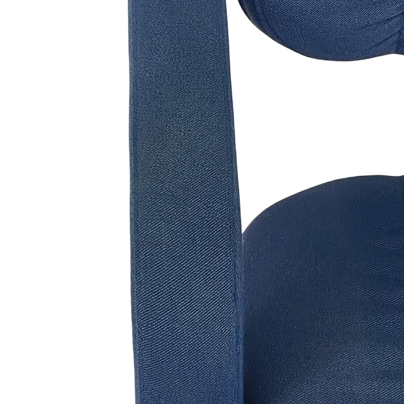 May include: Close-up of a dark blue fabric chair with a textured surface. The chair has a high back and a wide seat.