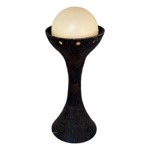 May include: A mid-century modern table lamp with a black ceramic base and a white globe shade.