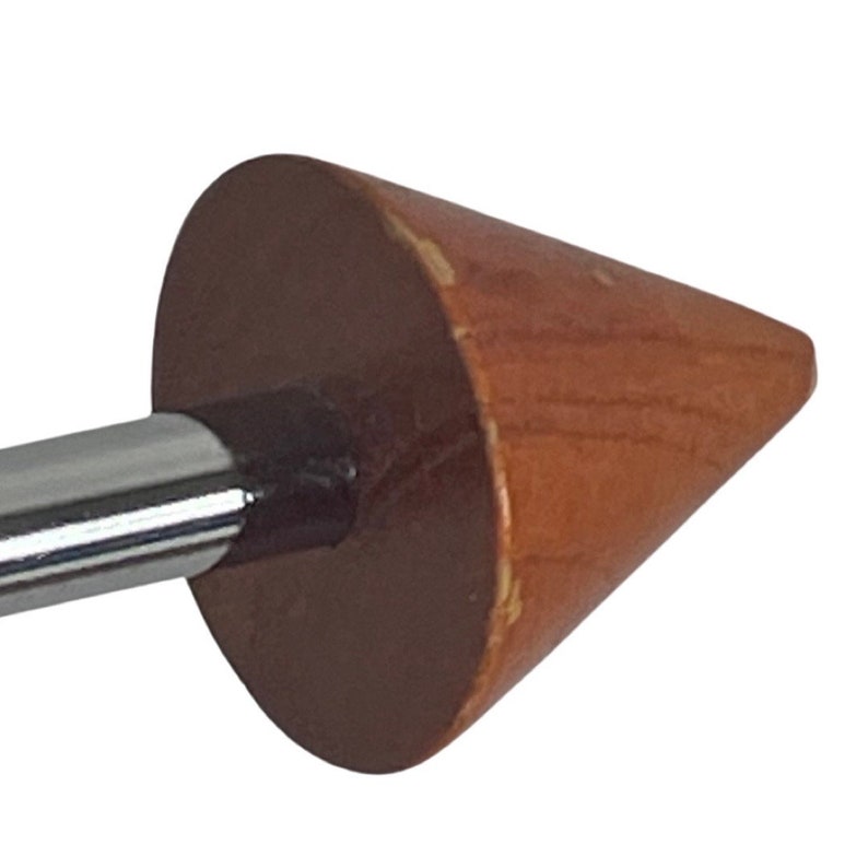 May include: A wooden cone-shaped finial with a chrome rod attached. The finial is a light brown color with a darker brown base.