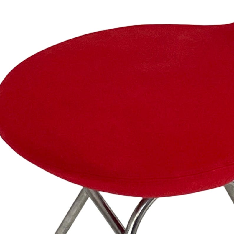 May include: A red upholstered chair with a chrome frame. The chair has a rounded, oval-shaped seat.
