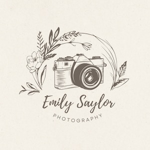 Puede incluir: Una ilustración en blanco y negro de una cámara vintage con detalles florales. El texto "Emily Saylor Photography" está debajo de la cámara.