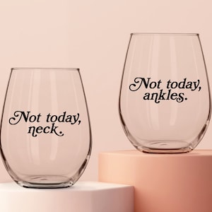 May include: Two clear glass wine glasses with the text "Not today, neck." and "Not today, ankles." printed on them.