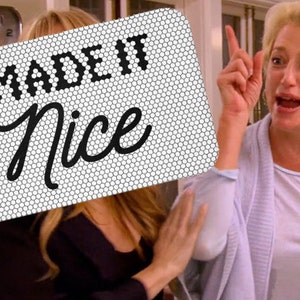 May include: A rectangular sign with a white honeycomb pattern background featuring the black text I MADE IT in a bold block font and the word Nice in a black cursive script. The sign is positioned over a scene showing a person with blonde hair.