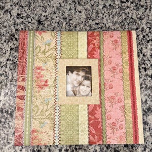 PRECIOSO álbum de recortes K & Co de 30,5 x 30,5 cm. Incluye diez páginas con protectores. Encuadernado con postes y se pueden añadir páginas adicionales.