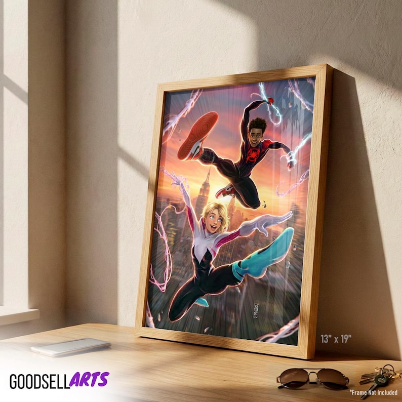 Op de afbeelding: Ingelijste kunstdruk met twee Spider-Man-personages in actie tegen een zonsondergang. Het kunstwerk zit in een houten lijst en meet 33 x 48 cm. Het Goodsell Arts-logo is zichtbaar onderaan.