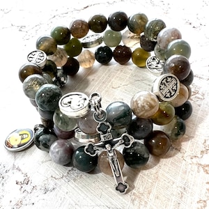 May include: A double-strand bracelet made of green, brown, and gray agate beads with silver charms, including a cross and a heart.