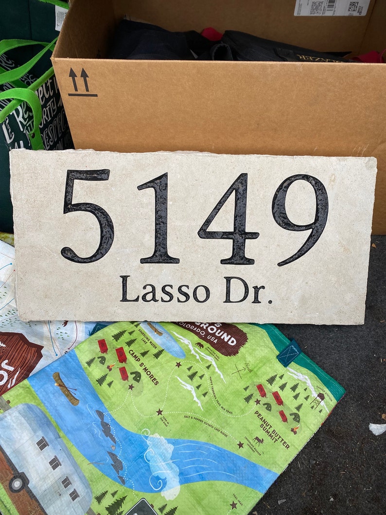 May include: A white stone house number plaque with black lettering. The number 5149 is displayed with the street name "Lasso Dr."