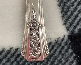May include: A silver necklace with a pendant made from a vintage silverware spoon. The spoon has a floral design.