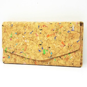 Peut inclure: Un portefeuille en liège avec un motif moucheté coloré. Le portefeuille a une fermeture à rabat et est fait de liège naturel.