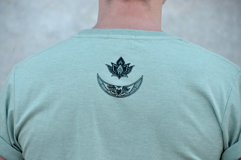 May include: A light green t-shirt with a black and white graphic of a crescent moon and a lotus flower.