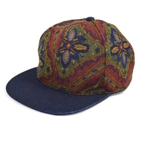 May include: A navy blue and multi-colored patterned baseball cap with a paisley design.