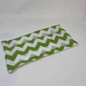 May include: A green and white chevron patterned fabric rectangle with a white fluffy backing.