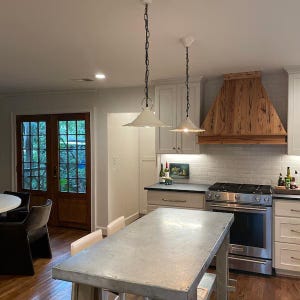 Set of two ceramic pendant lamps, hanging under kitchen island in a modern rustic style farmhouse kitchen