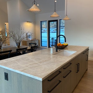 Set of 3 Handmade white ceramic pendant light hanging above a kitchen island.