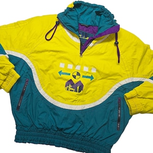 May include: A vintage yellow, teal, and purple anorak jacket. The jacket features a half-zip closure, a drawstring hood, and a graphic design on the front. White accents and a ribbed hem complete the design. The jacket has two zippered pockets.