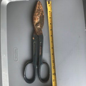 May include: A rusty Wiss brand tin snips with a black handle and the words "Drop Forged" on the side. The snips are about 12 inches long.