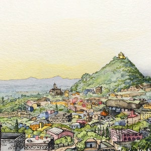 Pu&ograve; includere: Un dipinto ad acquerello di un paesaggio urbano con una collina sullo sfondo. La collina &egrave; ricoperta di alberi verdi e ha un piccolo edificio in cima. La citt&agrave; &egrave; composta da molti piccoli edifici, alcuni dei quali sono rossi, gialli e blu. Il cielo &egrave; di un colore azzurro chiaro.