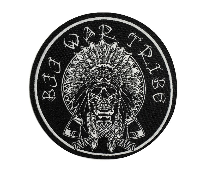 May include: Circular black and white patch with a skull wearing a Native American headdress. The words "SEE WAR TRIBE" are in a circle around the skull. Two crossed tomahawks are below the skull.