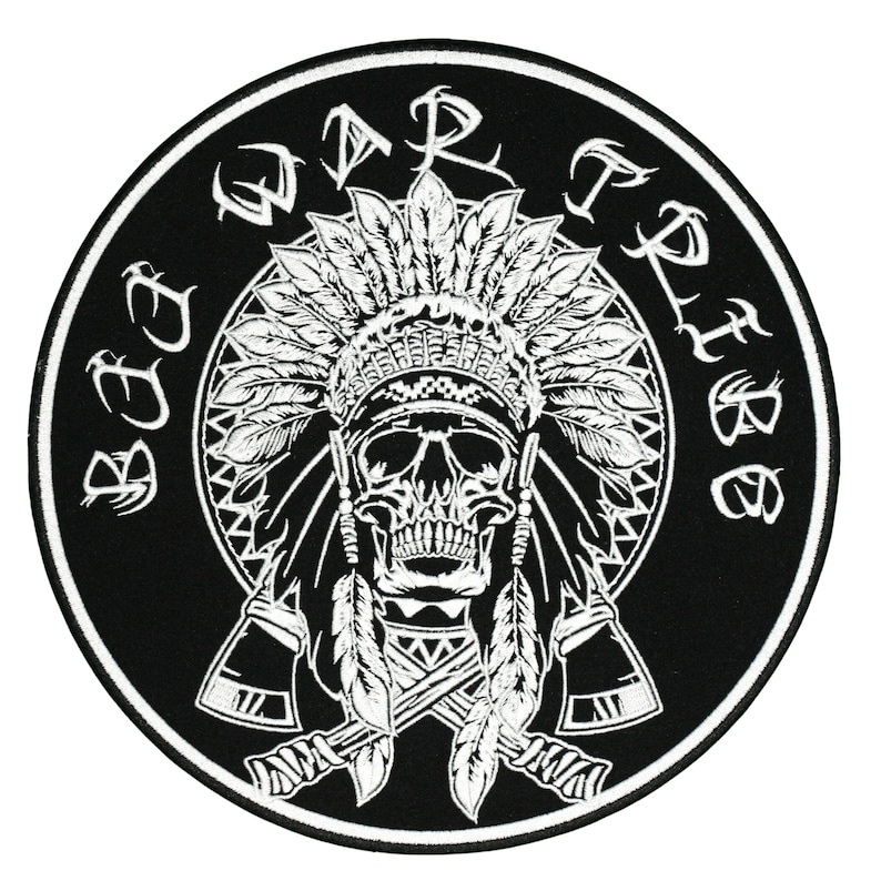 May include: A circular black and white patch with a skull wearing a Native American headdress. The words "Bad Tribe" are in a circle around the skull. Two crossed tomahawks are below the skull.