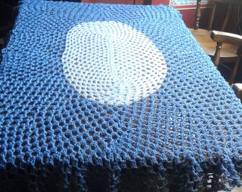 Handmade crochet oval tablecloth with white medallion on ocean blue background