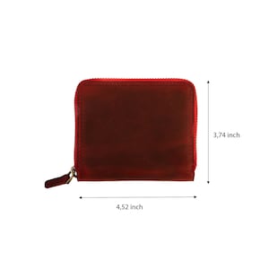 May include: A red leather zippered wallet measuring 4.52 inches wide and 3.74 inches tall.