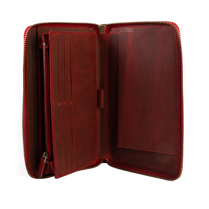 May include: A red leather zippered wallet with multiple card slots and a large pocket. The wallet is open and empty.