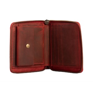 May include: Red leather zippered wallet with a small interior pocket and multiple card slots.