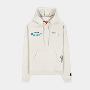 Puede incluir: Sudadera con capucha color crema con bolsillo delantero y capucha con cordón. La parte delantera presenta el texto "EVER YOURS, Vincent" en escritura azul. Texto adicional y un pequeño gráfico están impresos en la parte delantera y la manga. Prenda casual y cómoda.
