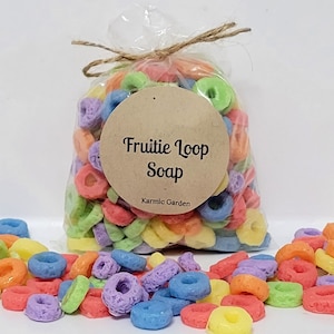 May include: A bag of colorful Fruitie Loop soap, a type of handmade soap that looks like cereal. The bag has a brown label that says "Fruitie Loop Soap" and "Karmic Garden".