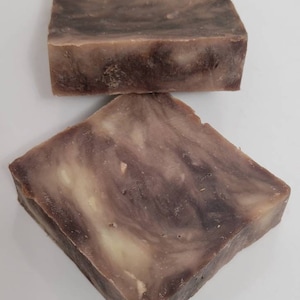 May include: Two bars of handmade soap with a brown and white marbled pattern.