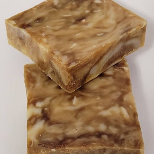 May include: Two bars of handmade soap with a brown and white marbled pattern.