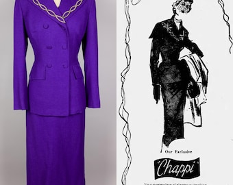 Könnte beinhalten: Ein leuchtend violetter Vintage-Anzug, bestehend aus einer doppelreihigen Jacke mit goldenen Verzierungen und einem passenden Rock. Die Jacke hat einen V-Ausschnitt und zwei Knopfreihen. Der Anzug wird auf einer Schaufensterpuppe präsentiert. Rechts ist eine Illustration eines Anzugs.