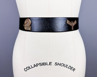 May include: A black leather belt with two decorative metal buckles. One buckle features a circular design and the other features the text "WILLS ROAD".